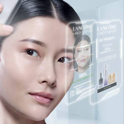 Mlada žena se diva do zrcadla s technologickym zobrazenim, ktere ukazuje informace o peči o pleť značky Lancome.