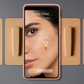 Mobilni aplikace Lancome e-SHADE FINDER zobrazuje obličej ženy s různymi odstiny make-upu a vedle ni je QR kod.