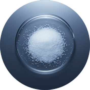 Hromadka bileho cukru na lesklem taliři s tmavym pozadim.