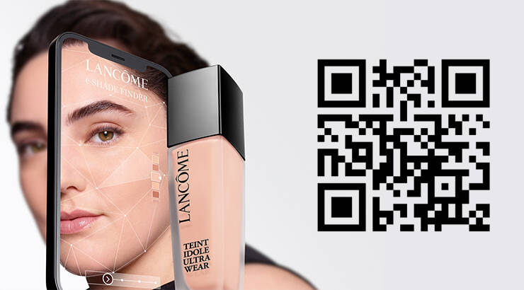 A smartphone displaying a virtual shade finder app for Lancome foundation, next to a bottle of Lancome Teint Idole Ultra Wear foundation and a QR code.