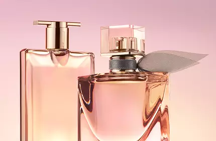 Two elegant perfume bottles are displayed against a soft pink background. One bottle has a sleek, rectangular shape, while the other is more rounded and adorned with a decorative element.