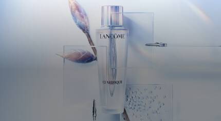 Stylova lahev pleťoveho tonika Lancome Clarifique na minimalistickem pozadi s přirodnimi prvky.