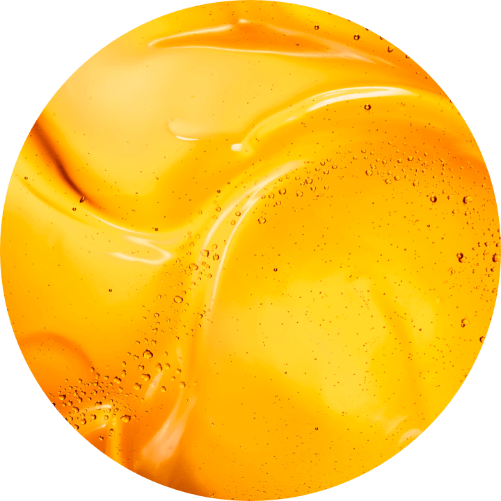 Hladky, leskly povrch žlute kapaliny s bublinkami, evokujici pocit svěžesti a pohody.