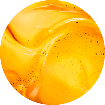 Hladky, leskly povrch žlute kapaliny s bublinkami, evokujici pocit svěžesti a pohody.