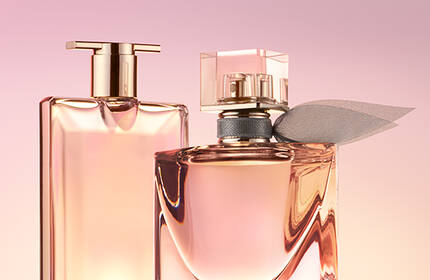 Two elegant perfume bottles are prominently displayed against a soft pink background. One bottle has a sleek rectangular shape, while the other is more rounded with a decorative accent.