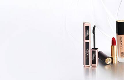 A minimalist display of Lancome perfume bottles arranged on white boxes against a light background.