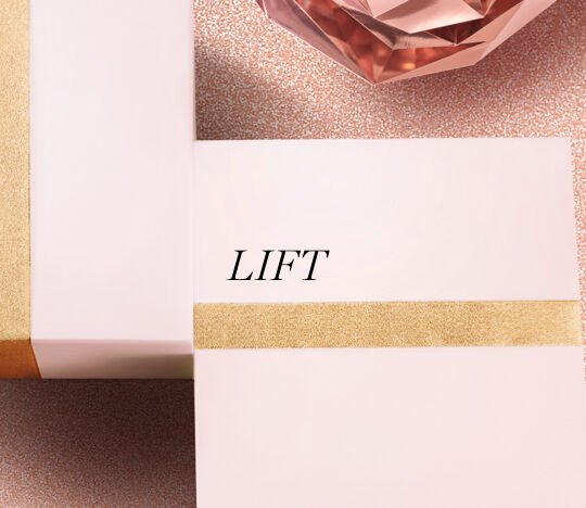 Two elegantly wrapped gift boxes in soft pastel colors, one featuring the word "LIFT" in a stylish font. A sparkling, rose-colored crystal decorates the scene, set against a glittery background.