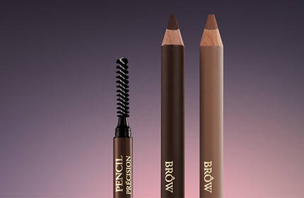 A close-up of two eyebrow pencils and a spoolie brush against a gradient background, showcasing different shades of brown.