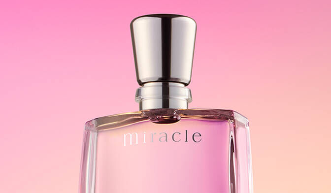 A bottle of perfume labeled "miracle" on a gradient pink background.