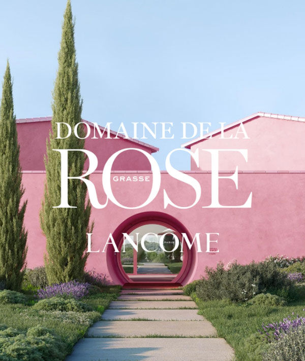 Růžova budova obklopena vegetaci, s napisem "Domaine de la Rose Lancome Paris".